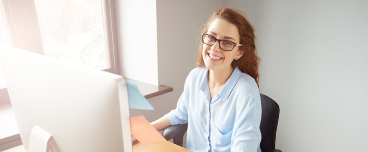 Une secrétaire assistante souriante devant son ordinateur