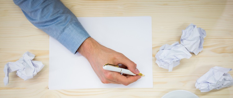 un homme écrivant sur une feuille blanche