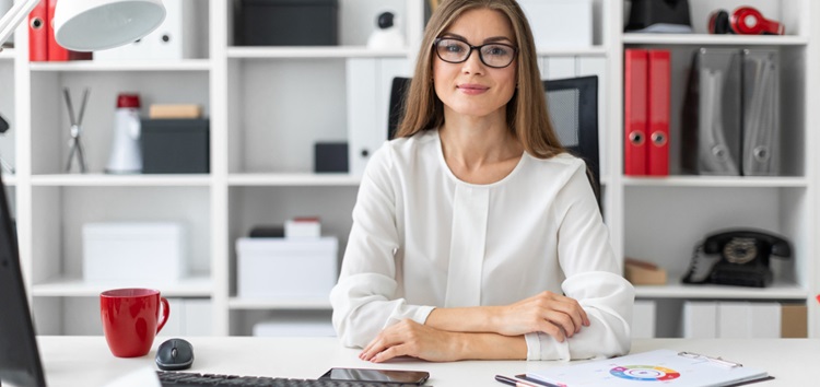 une femme à son bureau et souriante