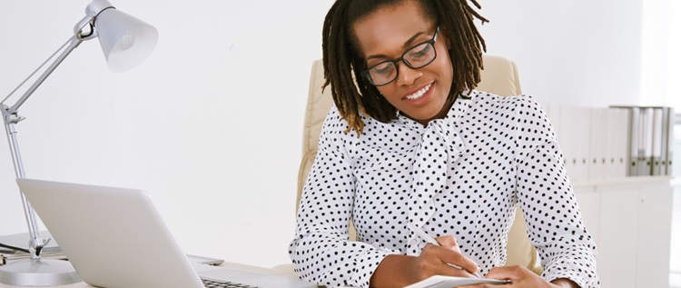 une jeune femme assise sur son bureau de travail