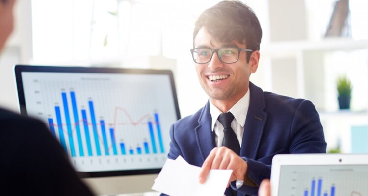 une personne travaillant dans la finance souriante en tendant des chiffres