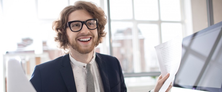 un jeune homme souriant tenant une lettre dans ses mains