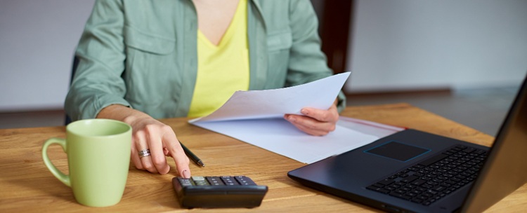 une femme travaillant sur un bureau devant son ordinateur portable