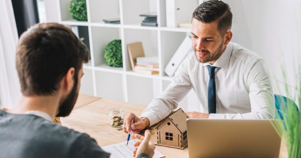 un agent immobilier au bureau avec un client